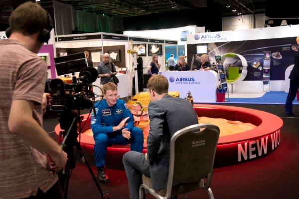 A cameraman films an interview with an astronaut, Tim Peake at an Airbus space exhibition.